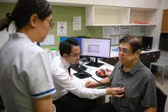 Dalam contoh proses pemeriksaan, Profesor Madya Kenneth Chew (tengah), perunding bagi Jabatan Kardiologi di Pusat Jantung Nasional Singapura (NHCS), memeriksa pesakit, Encik Lam Theam Fatt (kanan), 63 tahun pada 20 Januari 2025. Pusat Jantung Nasional Singapura (NHCS) dan Yayasan Lien bakal mengadakan daya utama Program ‘Heartlanders’ bagi membantu 9,000 pesakit mengalami kegagalan jantung dalam tempoh lima tahun akan datang.