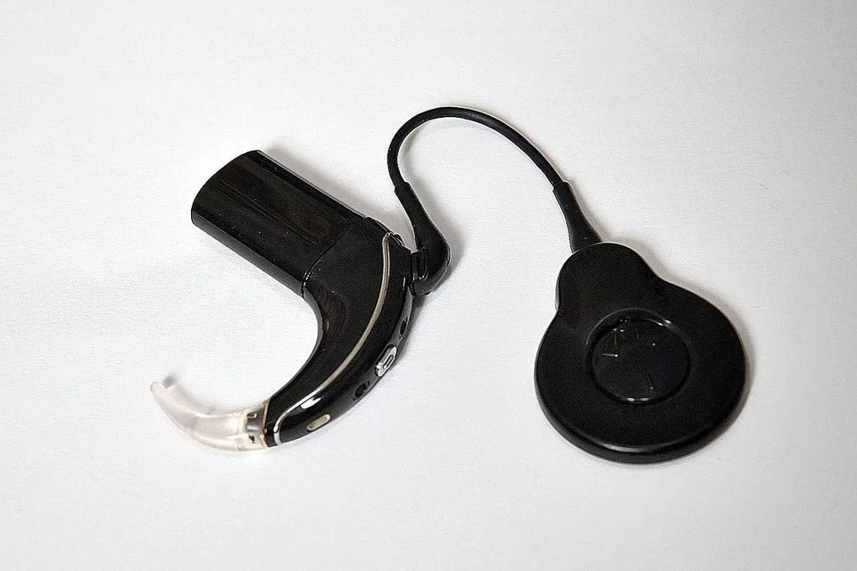 ALAT BANTUAN: Cik Roslinah Rawi dan suami, Encik Mohamad Jantan B Mis tunjukkan implan cochlear (gambar atas) yang dipasang ke telinganya untuk membantu beliau mendengar dengan lebih jelas. - Foto BH oleh CHONG JUN LIANG