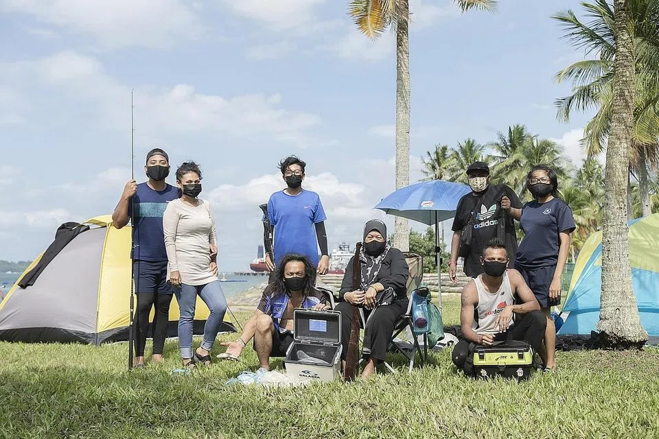 RINDU BERKHEMAH SEKELUARGA: Encik Zurayni Mohd Suthi (kiri di depan) dan isterinya, Cik Johiah Abu (sedang duduk) bersama keluarga dan beberapa saudara mereka ketika berkhemah dan memancing di Taman Pasir Ris semalam. - Foto BH oleh HARITH MUSTAFFA