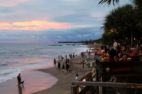 Pelancong menikmati pemandangan matahari terbenam di pantai Canggu di Bali, Indonesia, pada Disember 2021.