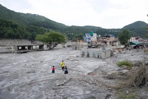 Kanak-kanak berjalan di celah bangunan yang terjejas akibat banjir glasier berhampiran sempadan Nepal-China yang meragut ratusan nyawa, di Trishuli Bazar, Nuwakot, Nepal, pada 31 Ogos.
