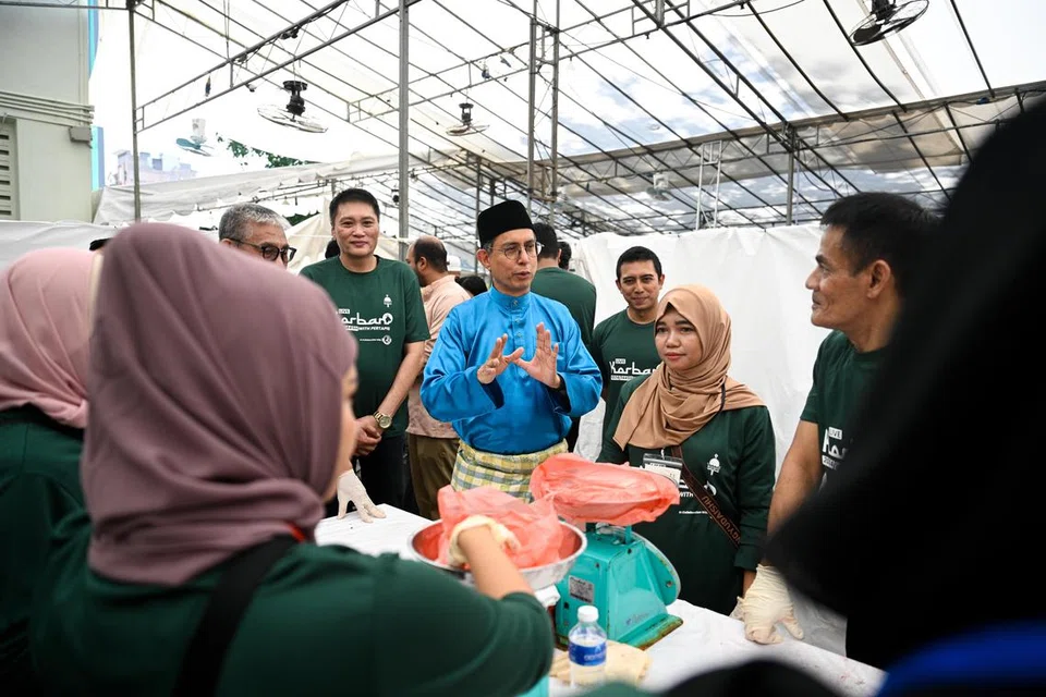 Profesor Madya Dr Muhammad Faishal Ibrahim (tengah) berinteraksi dengan sukarelawan yang terlibat dalam acara korban secara langsung di Rumah Peralihan Pertapis pada 17 Jun.