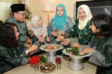 RUMAH TERBUKA: Cik Hamidah Abdul Karim (dua dari kanan) bersama keluarga akan berkongsi kisah tentang gubahan bunga Melayu kepada para tamu sempena Pesta Seni Antarabangsa Singapura tahun ini. - Foto JOHARI RAHMAT