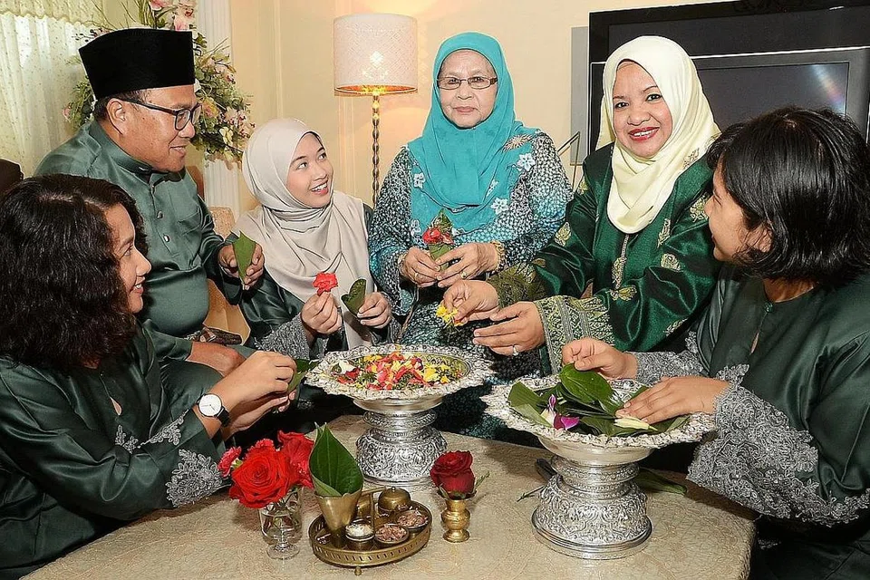 RUMAH TERBUKA: Cik Hamidah Abdul Karim (dua dari kanan) bersama keluarga akan berkongsi kisah tentang gubahan bunga Melayu kepada para tamu sempena Pesta Seni Antarabangsa Singapura tahun ini. - Foto JOHARI RAHMAT