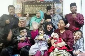 REDA DENGAN SITUASI: Walaupun tidak dapat menyambut Hari Ibu bersama ibu yang tersayang tahun ini, Cik Siti Noraisah Ali (barisan belakang, dua dari kiri) berkata beliau menerima qada dan qadar atas pemergian ibunya Allahyarhamha Salha Mesbee (duduk tengah) . Foto diambil semasa sambutan Hari Raya pada Jun 2018. - Foto ihsan SITI NORAISAH ALI