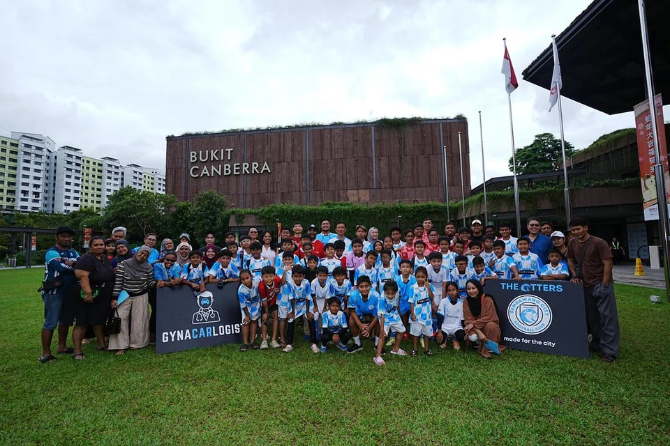 Menteri Kesihatan, Encik Ong Ye Kung (tengah, belakang), yang juga Anggota Parlimen GRC Sembawang bersama jurulatih dan pelatih Kelab Bola Sepak (FC) Sembawang City serta ibu bapa di SPARKS@Bukit Canberra.