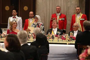 PERKUKUH IKATAN DUA NEGARA: Puan Halimah Yacob menarik perhatian mengenai hubungan ekonomi yang kukuh antara Singapura dengan Belanda semasa berucap di majlis jamuan negara di Istana Diraja Amsterdam. Turut dalam gambar ialah suami beliau, Encik Mohamed Abdullah Alhabshee (kanan, sedang duduk) serta Raja Willem-Alexander dan Ratu Maxima. - Foto MCI