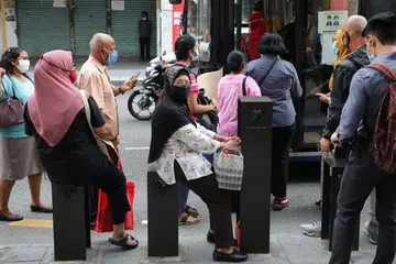 Orang ramai memakai pelitup sebelum menaiki bas di Kuala Lumpur, Malaysia. - Foto REUTERS