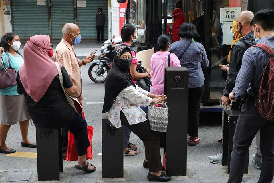 Orang ramai memakai pelitup sebelum menaiki bas di Kuala Lumpur, Malaysia. - Foto REUTERS
