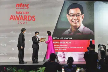 TERIMA PINGAT KEHORMATAN: Timbalan Perdana Menteri Heng Swee Keat menerima Pingat Kehormatan, pengiktirafan tertinggi Hari Buruh daripada Presiden NTUC, Cik Mary Liew. Bersama mereka ialah Setiausaha Agung NTUC, Encik Ng Chee Meng. - Foto DESMOND WEE 