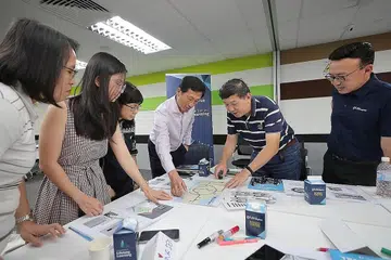 KEMAHIRAN DAN KECEKAPAN BARU: Menteri Pendidikan, Encik Ong Ye Kung (tiga dari kanan) dan Ketua Pegawai Eksekutif NTUC Learning Hub, Encik Kwek Kok Kwong berinteraksi bersama peserta dalam kelas pengekodan di NTUC Learning Hub semalam. - Foto BH oleh GAVIN FOO