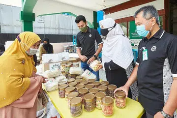 TERIMA HABUAN: Cik Rahmah Alwi (tudung kuning) antara 700 keluarga penerima zakat Persatuan Muhammadiyah yang baru-baru ini menerima habuan kuih Hari Raya dan juga wang zakat. - Foto BH oleh ROSLEE ABDUL RAZAK