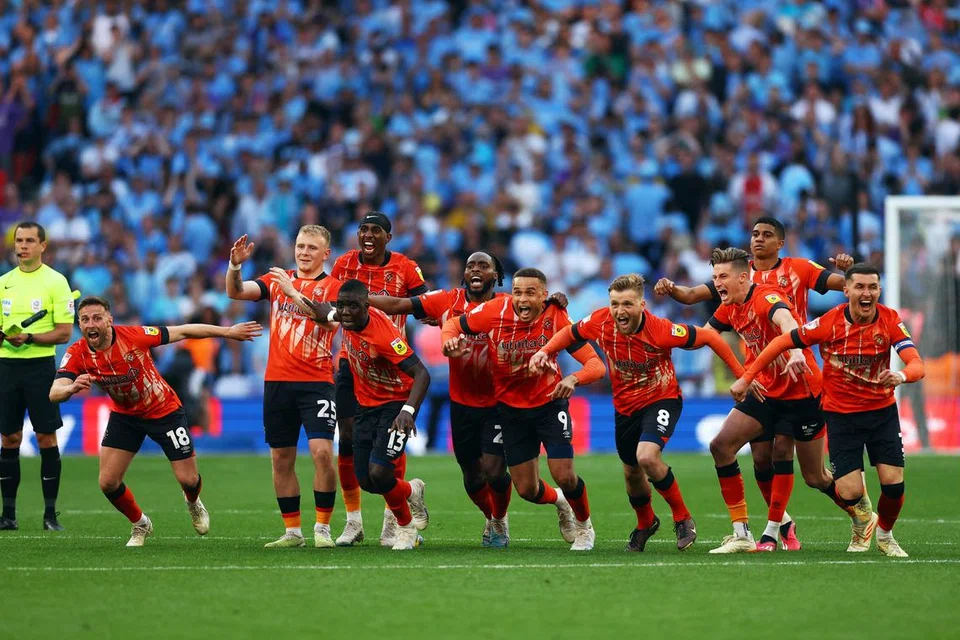GOL MENUJU KE EPL: Pemain Luton Town meraikan gol sepakan penalti semasa perlawanan akhir menentang Coventry yang berkesudahan dengan seri 1-1 dan jaminan tempat kelab mereka di Liga Perdana England (EPL).