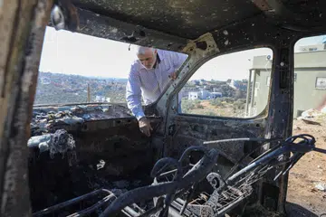 HENTIKAN TINDAKAN GANAS: Seorang rakyat Palestin memeriksa sebuah kereta yang dibakar oleh sekumpulan peneroka Israel di Salfit, Tebing Barat, pada 3 Disember.