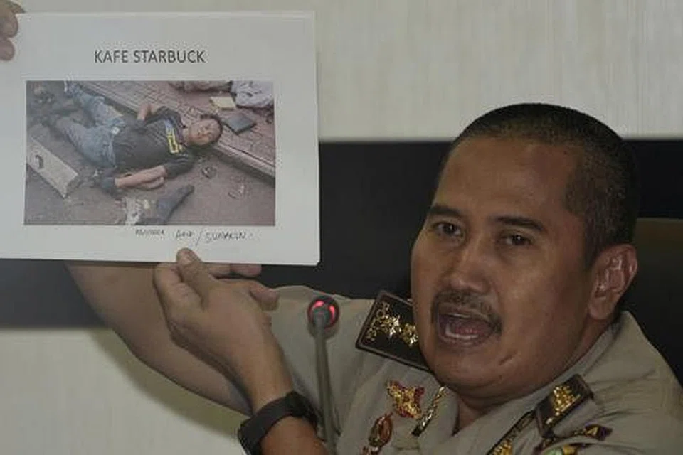 TERPENGARUH DI PENJARA: Pegawai polis Jakarta, Encik Musyafak, menunjukkan gambar seorang militan, Afif, yang terbunuh dalam serangan di Jalan Thamrin di Jakarta. - Foto REUTERS