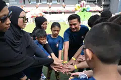 Naib Pengerusi CDC North East yang juga Penasihat bagi Pertubuhan Akar Umbi GRC Sengkang, Dr Elmie Nekmat (enam dari kiri), bersama penerima bantuan Stars @ North East pada 20 Jun semasa acara ‘The Kindness Warrior: Families for School Transport’ di Our Tampines Hub.