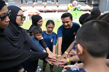 Naib Pengerusi CDC North East yang juga Penasihat bagi Pertubuhan Akar Umbi GRC Sengkang, Dr Elmie Nekmat (enam dari kiri), bersama penerima bantuan Stars @ North East pada 20 Jun semasa acara ‘The Kindness Warrior: Families for School Transport’ di Our Tampines Hub.