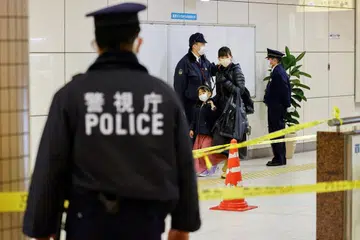 TEMPAT KEJADIAN: Seorang wanita dan kanak-kanak berjalan melintasi kawasan kejadian tikaman di stesen Todai-mae Tokyo berhampiran Universiti Tokyo. - Foto REUTERS