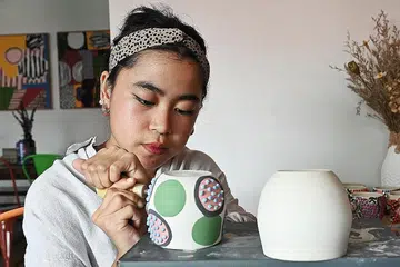 ASAH KEMAHIRAN: 'Cawan pelik' mengambil masa empat jam untuk membentuk cawan itu dan beberapa hari untuk mereka bentuk dan mengecatnya. - Foto BH oleh KHALID BABA