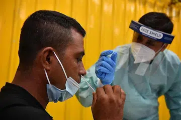 LEBIH SENANG, SELESA: Encik Hossan Md Sumon (kanan), yang telah dilatih menggunakan ART, membimbing rakan pekerja migrannya, Encik Rahman Mizanuir, melakukan ujian itu sendiri. - Foto BH oleh CHONG JUN LIANG