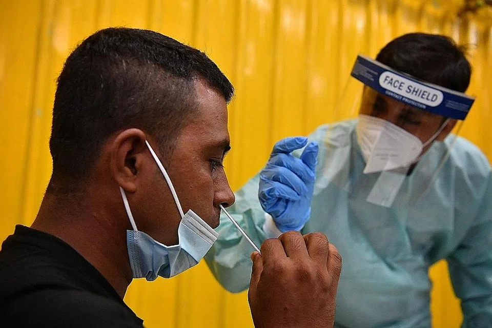 LEBIH SENANG, SELESA: Encik Hossan Md Sumon (kanan), yang telah dilatih menggunakan ART, membimbing rakan pekerja migrannya, Encik Rahman Mizanuir, melakukan ujian itu sendiri. - Foto BH oleh CHONG JUN LIANG