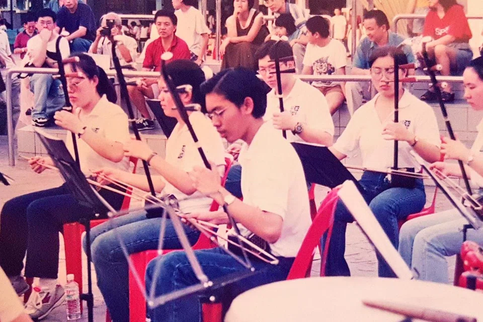 Encik Faizal (tengah) menyertai orkestra Cina semasa belajar di politeknik. Sebagai permulaan, beliau mempelajari ‘Erhu’ – alat muzik bertali seakan biola  –demi mencapai impiannya untuk belajar main ‘Guzheng’.