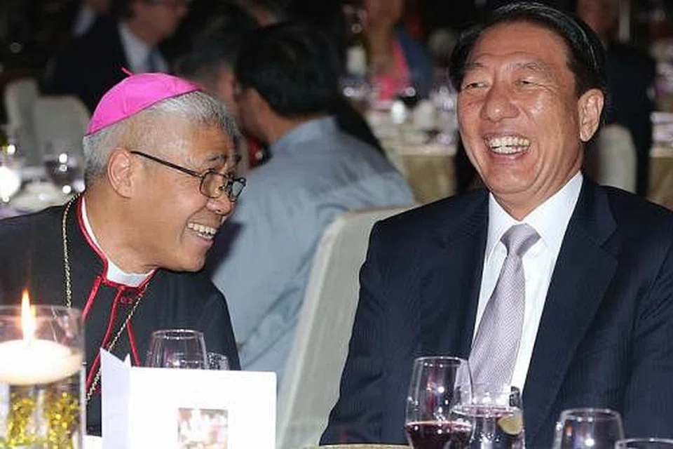 JALIN IKATAN MUHIBAH: Encik Teo (kanan) beramah mesra dengan Ketua Biskop William Goh di majlis jamuan malam bagi mengumpul dana bagi gereja Church of Transfiguration yang akan dibina di Punggol. - Foto THE STRAITS TIMES