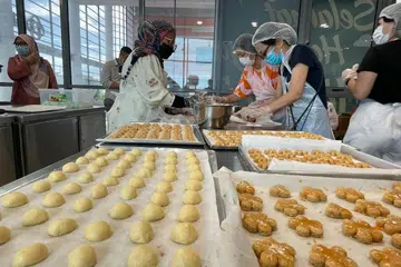 Lebih 100 sukarelawan mendaftar dan turun padang ke studio membuat kuih di Kelab Masyarakat Siglap selama seminggu untuk membakar 50,000 kuih yang akan diagihkan kepada keluarga berpendapatan rendah.