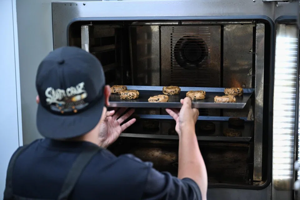 Encik Hanif membakar biskut, Chewy Chocolate Chips, yang nanti disejukkan sebelum ia dibungkus untuk diletakkan dalam mesin layan diri. Pencuci mulut diisi dalam mesin layan diri semula setiap dua hari. 
