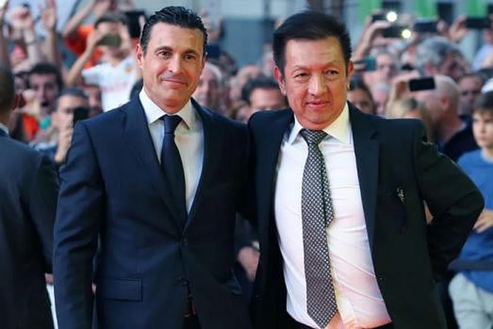 HERO VALENCIA: Pemilik baru Valencia, Peter Lim (kanan), dan presiden kelab, Amadeo Salvo, bergambar di depan Stadium Mestalla sebelum perlawanan menentang Elche Sabtu lalu. Kehadiran Lim disambut meriah ribuan penyokong kelab itu. - Foto AFP