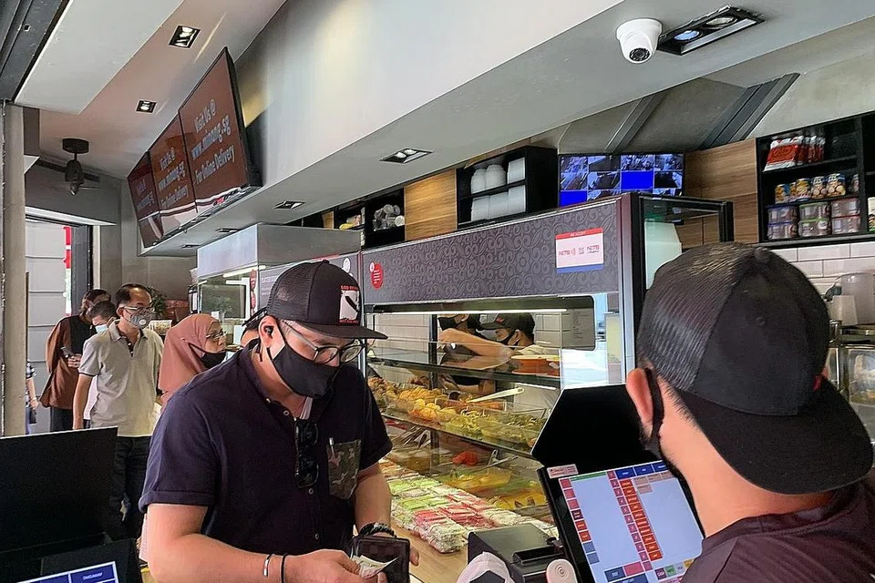 BERATUR: Pelanggan dapat dilihat mematuhi jarak selamat semasa menunggu giliran untuk membayar pesanan makanan mereka yang telah dibungkus di restoran Rumah Makan Minang semalam. - Foto BH oleh FAKHRURADZI ISMAIL