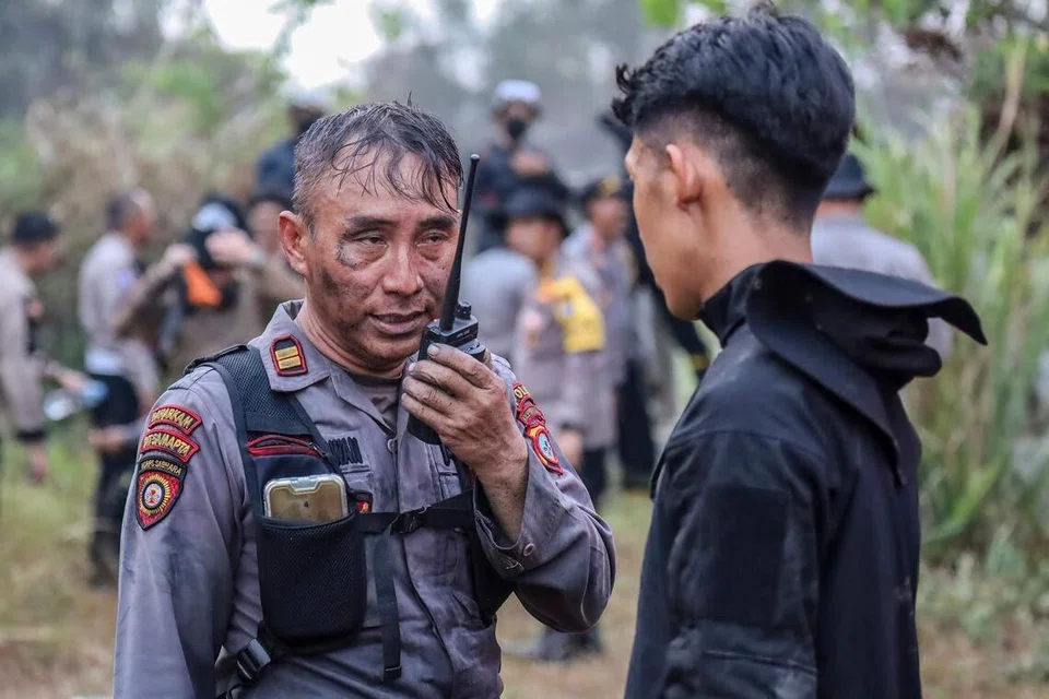 Seorang anggota polis yang wajah dan pakaiannya diselaputi jelaga menggunakan alat komunikasi untuk menghubungi pasukannya selepas memadamkan kebakaran hutan di Handil Bakti, daerah Barito Kuala, Kalimantan Selatan, Indonesia, pada 8 Oktober 2026. Jerebu tebal akibat kebakaran hutan di Sumatera dan Kalimantan terus menjejaskan beberapa kawasan di Indonesia, Malaysia dan Singapura sejak beberapa minggu lalu, ketika pihak berkuasa Indonesia bertungkus-lumus mengawal kebakaran yang memusnahkan kawasan hutan yang luas.