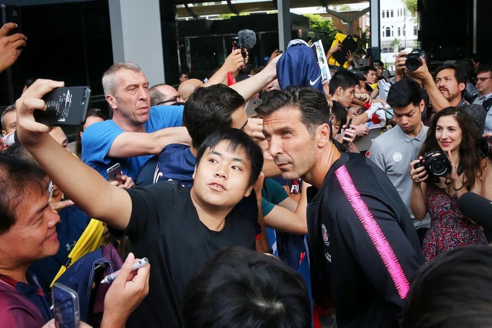 BERSWAFOTO DENGAN LEGENDA: Penyokong bola sepak tempatan tidak mahu melepaskan peluang melihat dan bergambar dengan penjaga gawang PSG Gianluigi Buffon. - Foto BH oleh GAVIN FOO 