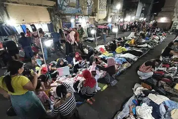 Pengunjung memilih pakaian di sebuah gerai jualan pakaian terpakai di Denpasar, Indonesia, di tengah perdebatan mengenai larangan import pakaian terpakai oleh pemerintah. 