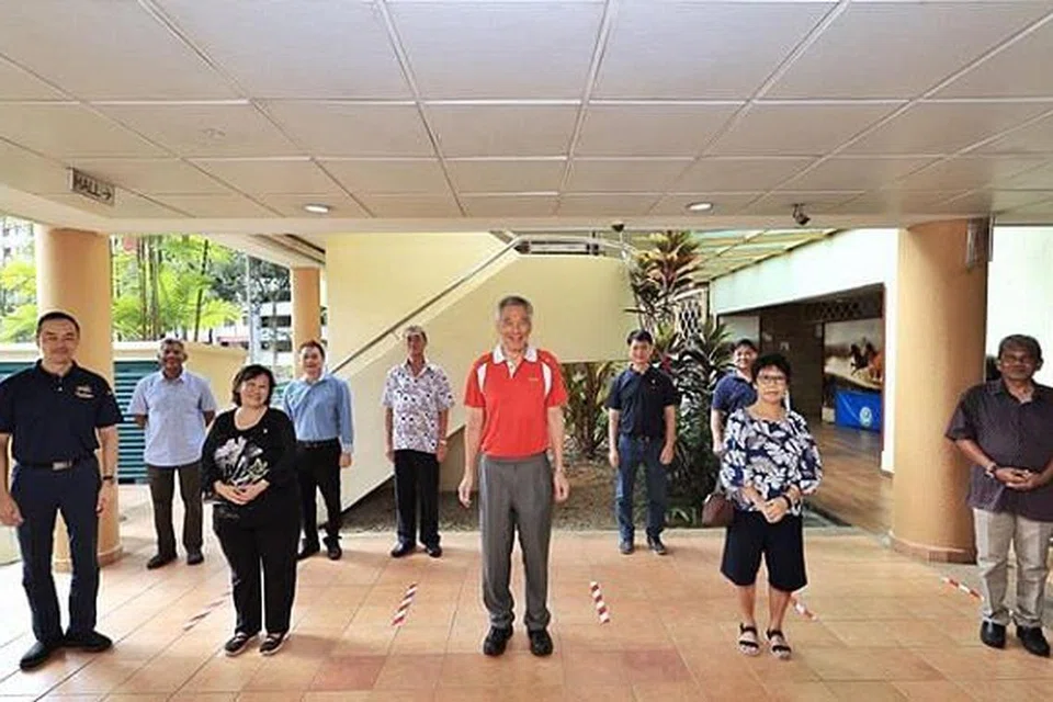 (tengah, baju merah) Encik Lee Hsien Loong bersama (paling kiri) Dr Koh Poh Koon dan para pemimpin akar umbi pastikan jarak sosial yang selamat dalam pertemuan perbincangan mereka. 