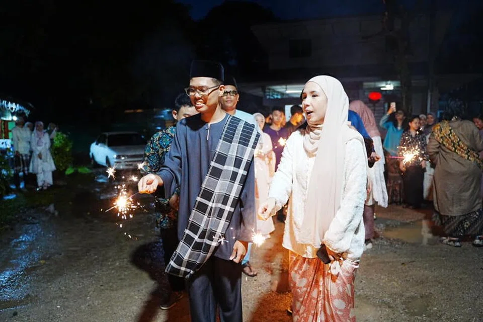 Eksekutif Audiens dan Perkembangan Berita Harian, Cik Kaiyishah Ayuni (kanan), semasa perjumpaan Hari Raya anjuran wadah digital BH, OMGxBH, yang berakhir dengan meriah apabila hadirin bermain bunga api di halaman rumah Mak Itam di Kampong Lorong Buangkok. 