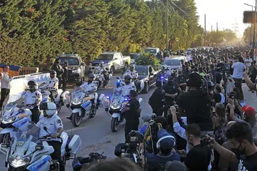 SELAMAT TINGGAL TERAKHIR: Ribuan orang membanjiri jalan raya Buenos Aires yang dilalui kereta jenazah Maradona ke tanah perkuburan di pinggir ibu kota Argentina itu untuk mengucapkan selamat tinggal terakhir. - Foto EPA-EFE, REUTERS
