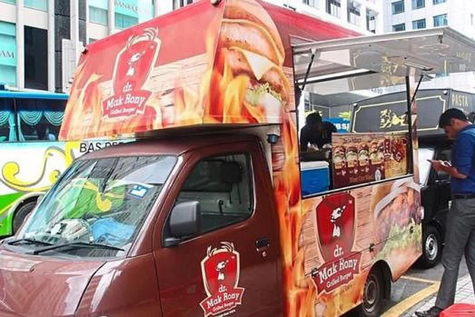 TRAK KREATIF: Usahawan muda yang kreatif menggerakkan perniagaan burger gril gourmet Dr Mak Rony menerusi trak yang mengelilingi bandar. - Foto THE STAR