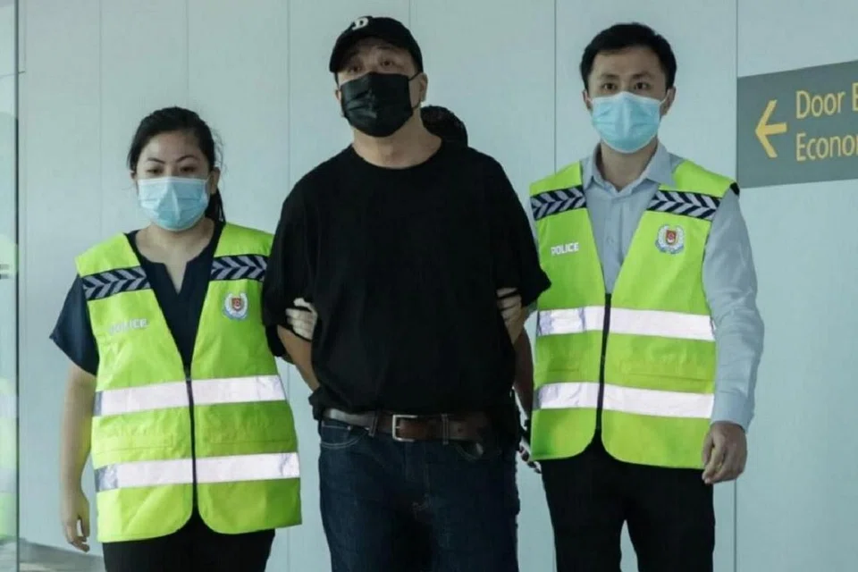 DITANGKAP AKHIRNYA: David Khong Siak Meng (tengah) kembali ke Singapura kelmarin dan ditangkap oleh pegawai dari Jabatan Ehwal Komersial. - Foto PASUKAN POLIS SINGAPURA