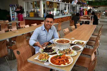 PILIHAN MAKANAN YANG DIMAMPUI: Encik Azmeer Aziz membuka kedai kopi, Setya Abadi Makan Place, di Aranda Country Club dekat Downtown East, kerana berharap memberi pilihan makanan yang dimampui di kalangan para pekerja yang bekerja di sekitar kawasan itu. - Foto fail