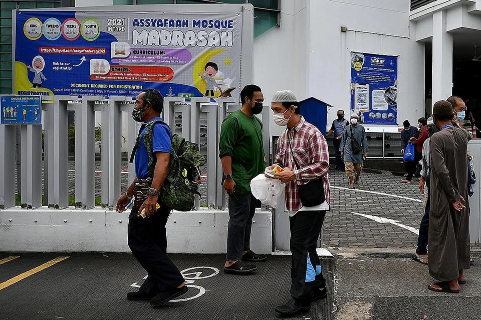 TENANG DAN TERATUR: Beberapa jemaah dilihat sedang keluar dari Masjid Assyafaah selepas sesi pertama solat Jumaat tengah hari semalam. - Foto BH oleh LIM YAOHUI 