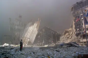 FOTO FAIL: Seorang lelaki berdiri di tengah-tengah runtuhan sambil mencari mangsa yang memerlukan bantuan selepas menara pertama Pusat Dagangan Dunia (WTC) runtuh di New York pada 11 September 2001. Menjelang ulang tahun ke-25 serangan itu, lebih 170,000 halaman dokumen didedahkan, menunjukkan bahan berbahaya termasuk asbestos, benzena dan dioksin dikesan di sekitar kawasan terjejas, walaupun penduduk ketika itu diberi jaminan bahawa udara selamat untuk dihidu.