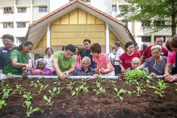 RUANG BERSAMA: Para pekebun baru dan lama akan sama-sama dapat menyemai minat dalam kegiatan tanam-tanaman menyusuli pelancaran 'Green Spaces @ South West'. Bersama para penduduk semasa pelancaran itu ialah Encik Desmond Lee (depan, berbaju hijau) dan Mayor CDC South West, Cik Low Yen Ling (depan, berbaju merah jambu). - Foto CMG