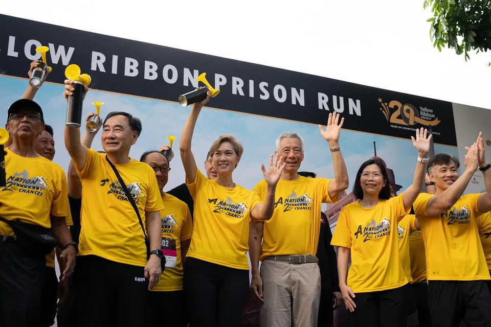 (dua dari kiri) Pengerusi Yellow Ribbon Singapura, Encik Phillip Tan Eng Seong; Menteri Penerangan dan Pembangunan Digital merangkap Menteri Kedua Ehwal Dalam Negeri, Cik Josephine Teo; Menteri Kanan, Encik Lee Hsien Loong; Pesuruhjaya Perkhidmatan Penjara Singapura, Cik Shie Yong Lee; Ketua Pegawai Eksekutif Yellow Ribbon Singapura, Encik Sunny Lee; bersama rakan kongsi CARE Network pada upacara permulaan larian 10 kilometer di Larian Penjara Yellow Ribbon (YRPR) 2024. 