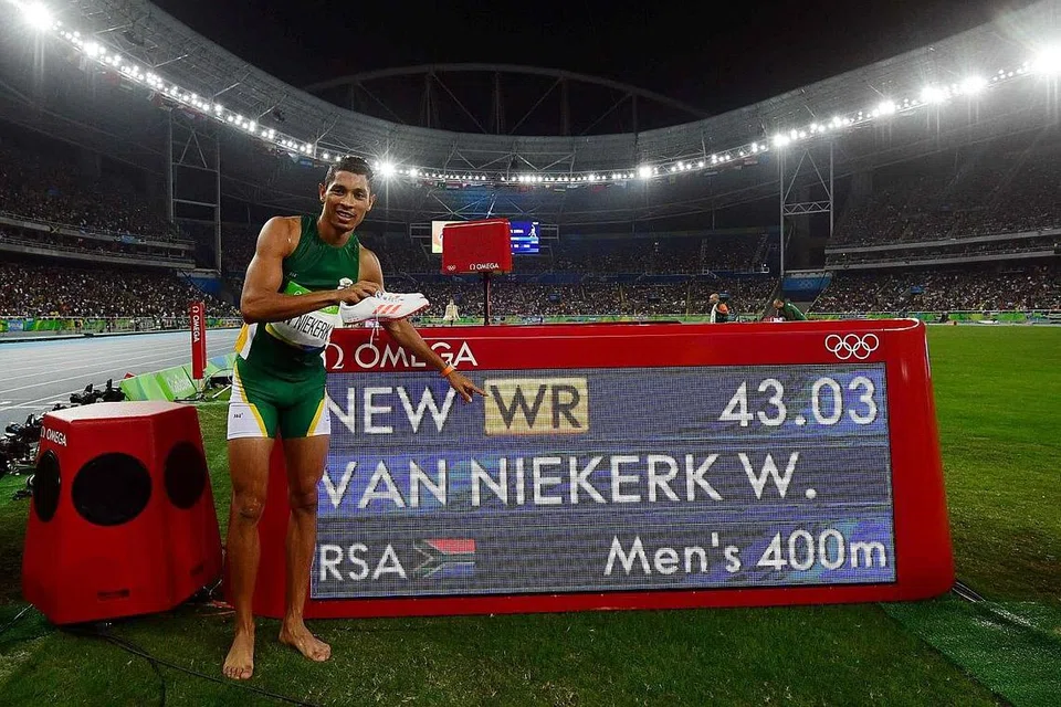 PERLUMBAAN SEMPURNA: Van Niekerk bergambar dengan papan masa elektronik yang menunjukkan rekod dunia yang dicatatnya dalam acara 400 meter. - Foto AFP
