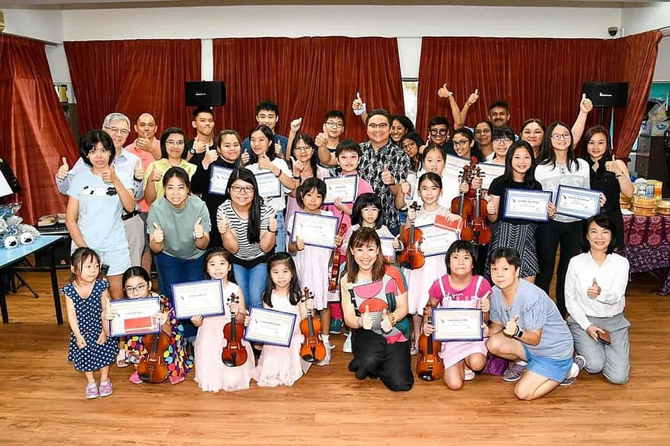 MUZIK UNTUK SEMUA: Peserta kelas biola projek 'Heartstrings' yang dipelopori keluarga Maya Raisha (barisan belakang, lima dari kanan), di Balai Rakyat Toa Payoh South turut mendapat sokongan AP Saktiandi Supaat. Foto ini dipetik pada 2019. - Foto SAKTIANDI SUPAAT / FACEBOOK