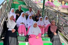 Mayor CDC South East, Encik Fahmi Aliman (barisan atas, tengah) bersama Pengerusi Lembaga Pengurusan Cik Ma’mun Suhaimi (barisan atas, kiri), Pengetua Madrasah Al-Ma’arif Al-Islamiah, Cik Maisarah Kasim (atas, kanan) bersama pelajar yang terlibat berfoto di tangga jejatas di mana karya mereka dipamerkan. 