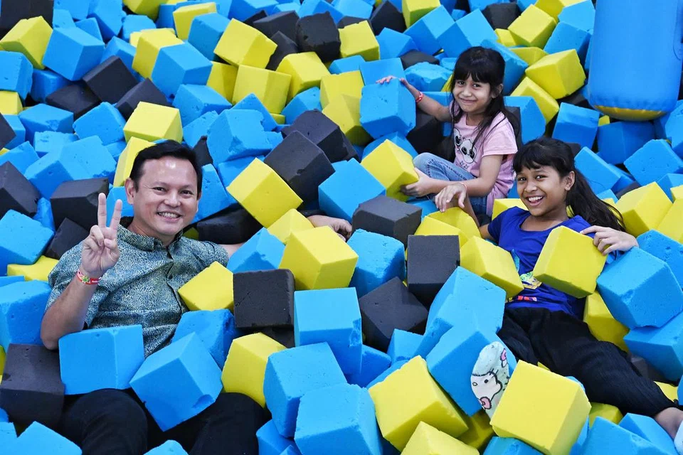 Menteri Negara Kanan (Pertahanan merangkap Kemampanan dan Sekitaran) yang juga pengerusi Yayasan Mendaki, Encik Zaqy Mohamad (kiri) mencuba Bouncetopia di sidang media Raikan Ilmu 2025 di Safra Choa Chu Kang pada 27 Jun. 