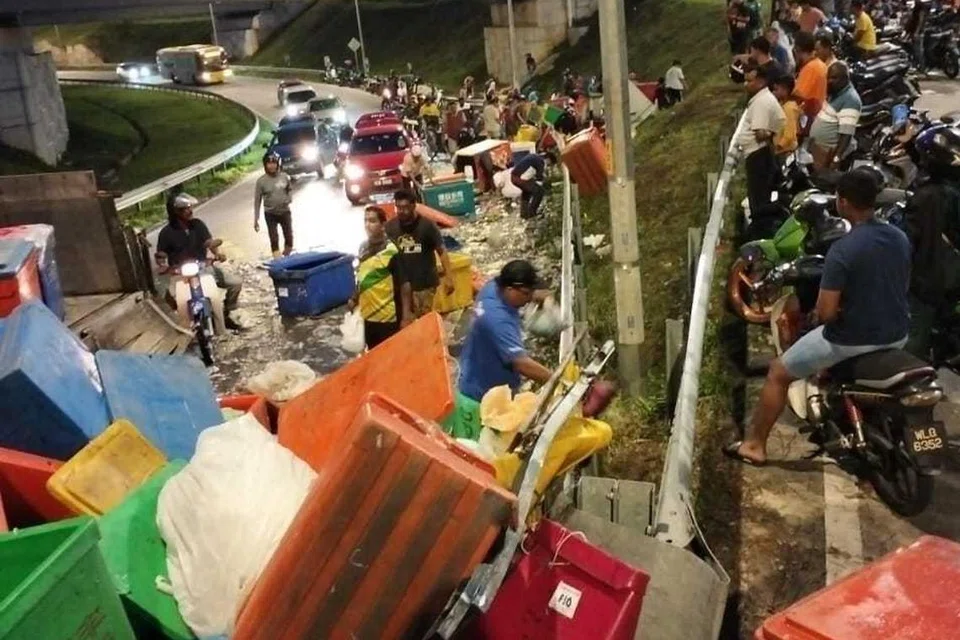 Orang ramai mengutip sotong dan ikan yang bertaburan di atas jalan selepas puluhan tong berisi hasil laut itu terjatuh akibat penghadang besi lori terbuka dalam kejadian di Jalan Kuala Selangor-Sungai Buloh berhampiran Kawasan Perindustrian Elmina, Sungai Pelong, malam tadi.