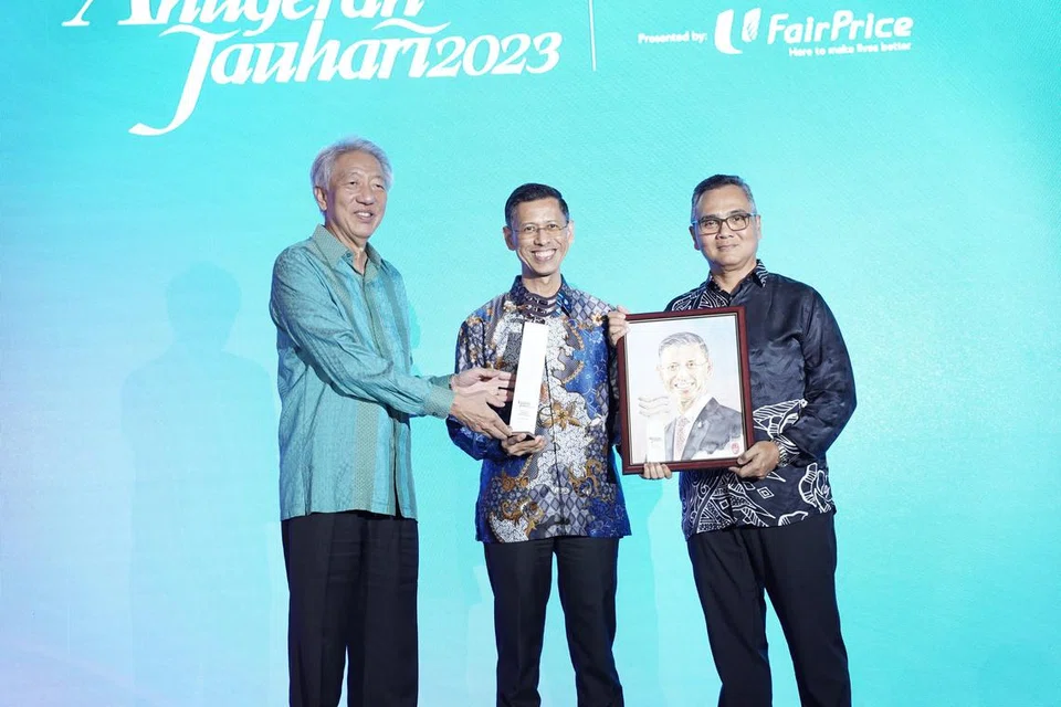 SUMBANGAN DIIKTIRAF: Encik Shahrin Abdol Salam (tengah) menerima anugerah daripada tetamu terhormat, Encik Teo Chee Hean (kiri) dan Encik Nazry Mokhtar (kanan) dalam satu majlis penyampaian Anugerah Jauhari Berita Harian yang diadakan di Four Seasons Hotel Singapore pada Jumaat.